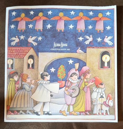 The cover of the "Neiman-Marcus Christmas Book 1982" featuring cartoon art by DePaola of a line of people in medieval costumes and domino masks. The night sky above is filled with five-pointed stars and a line of angels with their backs turned.

[Begin text in next photo because it won't all fit in its alt text.]

HIS/HER GIFT 1982

Fitness can be a real trip, with the help of this year's His/Her Gift for Christmas 1982.

Possibly the best inducement to exercise since the discovery of the mirro…